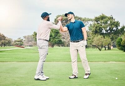 Two golfers greeting each other with a fist bump on a golf course